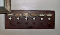 These are switches found directly to the left upon entey to the rectory. Name 1 is Reverend Desmond, Name 2, 3, 4 blank, Name 5 is Reverend Maxa, and Number 6 is alarm. A push button and a switch are below each name. This device is an early version of a pager and cheaper and less intrusive than an intercom. Rectories and convents, although not quite monastic, were certainly subdued and contemplative places. When visitors arrived at the rectory to see a particular priest, he would have been summoned, usually by the housekeeper, with this device. Each resident had their coded number of rings or chimes programmed into the system and they were summoned to the vestibule by their individual coded chime. Most rectories were large places and decorum would have prevented the house keeper from yelling upstairs for Father so and so. [Thank you Thomas DeMaria for this explanation.] (Photo courtesy of Renee Jackson)