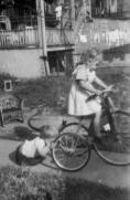 Joyce Peneschi on her first tricycle, with her brother, Tom, holding the tire so she can't ride - a friendly sister and brother 'fight'. (Photo Courtesy of Joyce Peneschi)